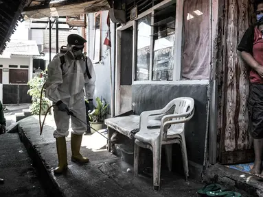 Warga menyaksikan petugas PMI Jakarta Timur  menyemprotkan disinfektan di permukiman Kampung Tengah, Kramat Jati, Minggu (23/8/2020). Penyemprotan sebagai langkah sterilisasi permukiman setelah warga di Kampung Tengah dilaporkan terpapar Covid-19. (Liputan6.com/Iqbal Nugroho)