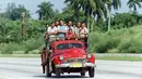 Sekelompok penduduk setempat mengendarai truk tua di jalan raya nasional di pinggiran Havana pada 4 Agustus 1991 untuk menghadiri kompetisi sebagai bagian dari XI Pan American Games. (AFP/Carlos Schiebeck)