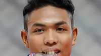 Sprinter Indonesia, Lalu Muhammad Zohri menggigit medali usai mengikuti kategori 100 meter dalam Kejuaraan Atletik Asia di Doha, Qatar, Senin (22/4). Zohri merebut medali perak dengan catatan waktu 10,13 detik yang juga memecahkan rekor pelari tercepat Asia Tenggara, Suryo Agung. (AP/Vincent Thian)