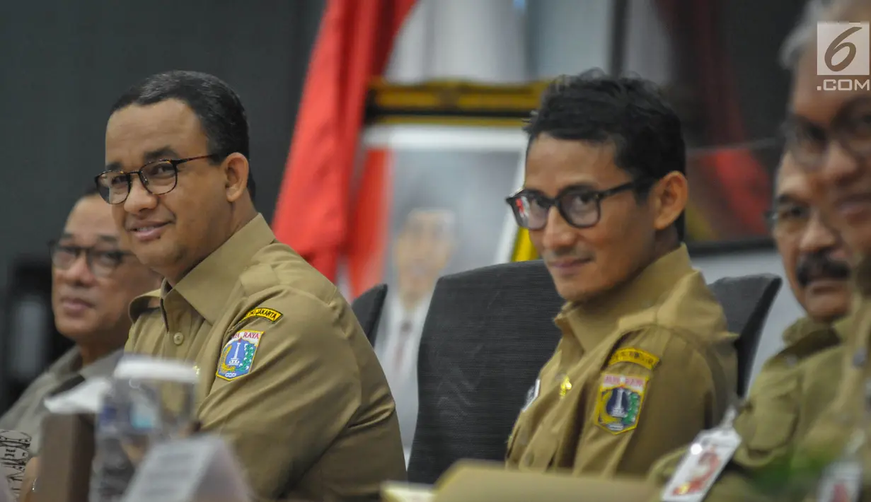 Gubernur dan Wakil Gubernur baru DKI, Anies Baswedan dan Sandiaga Uno bersiap menggelar rapat dengan jajaran pejabat Pemprov DKI Jakarta di Balai Kota, Selasa(17/10). Anies-Sandi tampak necis mengenakan pakaian dinas PNS. (Liputan6.com/Faizal Fanani)