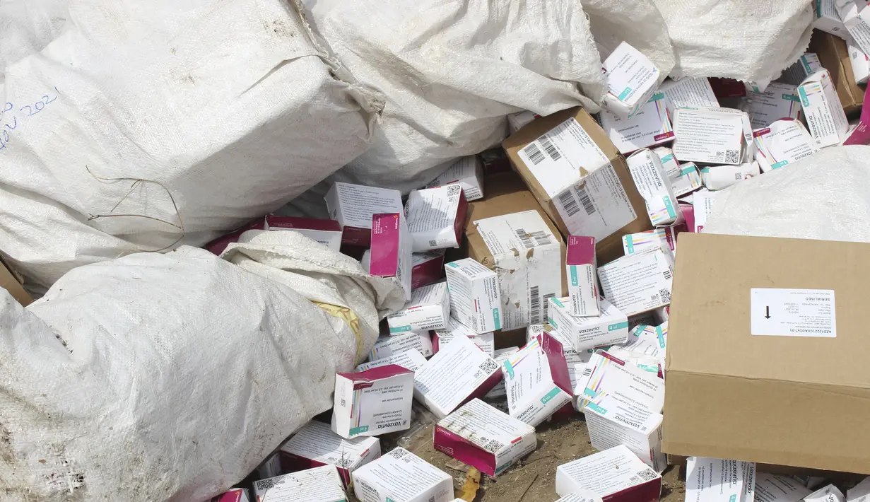 Vaksin COVID-19 yang kedaluwarsa siap dihancurkan oleh pejabat pemerintah di Abuja, Nigeria, Rabu (22/12/2021). Sebuah bulldozer dikerahkan untuk menghancurkan vaksin corona merek AstraZeneca tersebut, yang dibungkus dalam dus-dus dan plastik. (AP Photo/Olamikan Gbemiga)