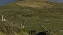 Sejumlah orang berjalan di kawasan Slea Head, Ventry, Irlandia, Selasa (27/12). Irlandia mendapat julukan Pulau Zamrud karena memiliki pemandangan alam yang hijau terang. (REUTERS / Clodagh Kilcoyne)