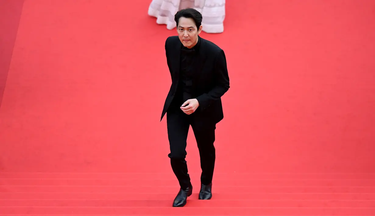 <p>Aktor dan sutradara Korea Selatan Lee Jung-Jae tiba untuk pemutaran film "Decision to Leave (Heojil Kyolshim)" selama Festival Film Cannes edisi ke-75 di Cannes, Prancis selatan, pada 23 Mei 2022. Dalam kesempatan itu Lee Jung Jae tampil dengan tuksedo serba hitam. Aktor &lsquo;Squid Game&rsquo; itu juga sama-sama mengenakan aksesoris dari Chopard yaitu jam tangan. (Antonin THUILLIER / AFP)</p>
