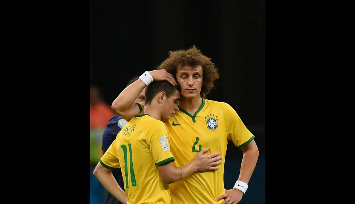 Dua pemain Timnas Brasil, David Luiz dan Oscar berpelukan usai dipermalukan Belanda 0-3 di laga perebutan tempat ketiga Piala Dunia 2014 di Stadion Nasional Brasilia, (13/7/2014). (AFP PHOTO/Vanderlei Almeida)