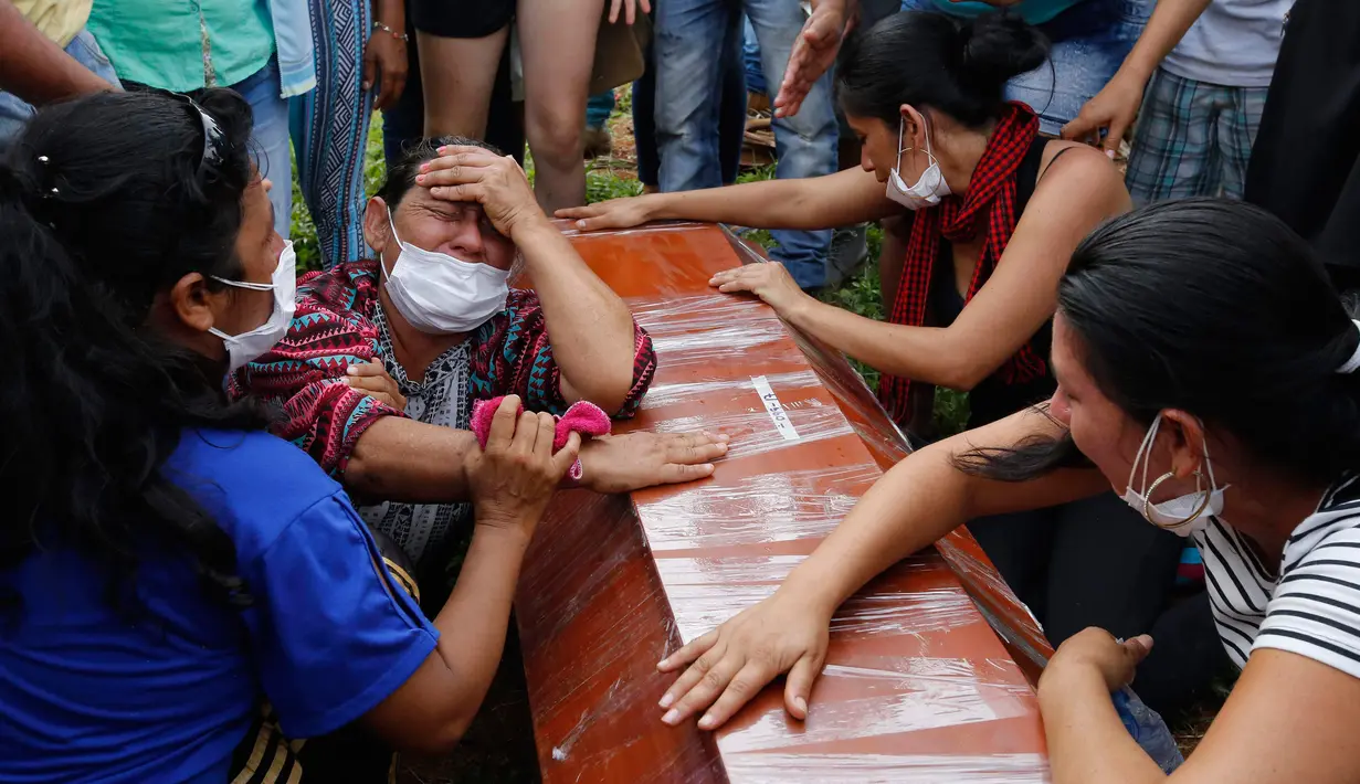 Sejumlah wanita menangis di samping peti mati dalam upacara pemakaman korban banjir dan tanah longsor di Mocoa, Kolombia, (3/4). Musibah ini memakan korban jiwa hingga ratusan orang dan menghancurkan seluruh lingkungan. (AP Photo / Fernando Vergara)