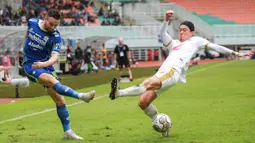 Pemain Persib Bandung, Marc Klok (kiri) menendang bola dibayangi pemain PSM Makassar, Kenzo Nabu saat laga lanjutan BRI Liga 1 2022/2023 antara Persib Bandung melawan PSM Makassar di Stadion Pakansari, Bogor, Selasa (14/02/2023). (Bola.com/Bagaskara Lazuardi)