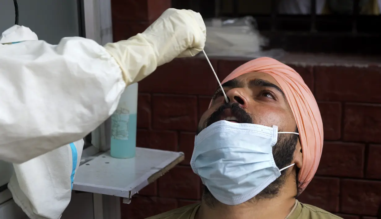 Petugas kesehatan mengambil sampel swab seorang pria untuk menguji virus corona Covid-19 di sebuah rumah sakit di Amritsar (2/9/2020). (AFP/Narinder Nanu)