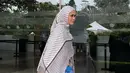 Kali ini ia tampil lebih cerah dengan kerudung panjang bermotif shemagh hitam putih dipadukan abaya coklat serta celana denim dan sneakersnya.  [@siviazizah]