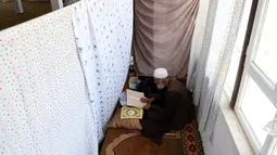 Umat muslim Afghanistan membaca Alquran di sebuah masjid di Kabul, Rabu (6/6). Jamaah beriktikaf memperbanyak membaca Al-Quran, berzikir, doa dan istigfar pada sepuluh malam terakhir Ramadan menanti datangnya malam Lailatul Qadar. (AP/Rahmat Gul)