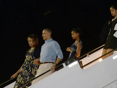Malia Obama, putri sulung presiden Amerika Serikat yang mengenakan balutan dress hitam putih (belakang) ini tertangkap kamera saat akan ke sebuah restoran di LA bersama teman-temannya, Senin, (08/07/14), (AFP PHOTO/Jewel Samad)