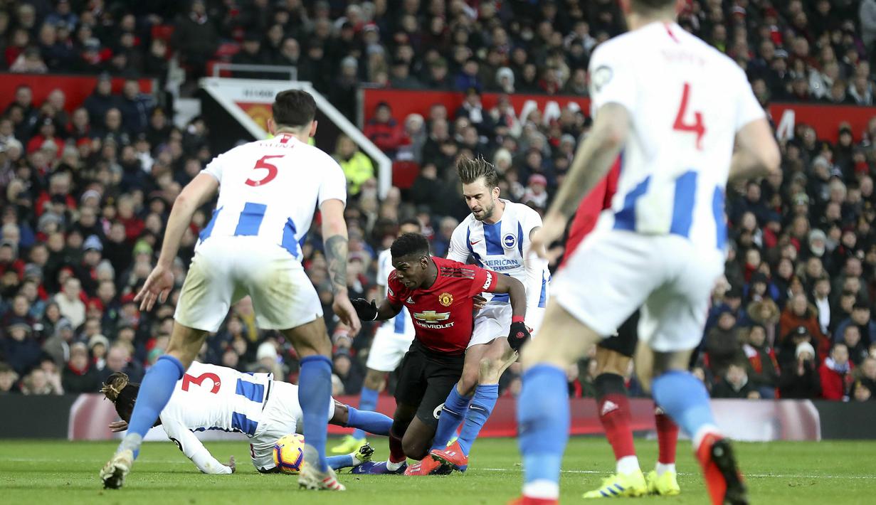 Gelandang Manchester United, Paul Pogba, berusaha melewati pemain Brighton and Hove Albion pada laga Premier League di Stadion Old Trafford, Sabtu (19/1). Manchester United menang 2-1 atas Brighton and Hove Albion. (AP/Martin Rickett)