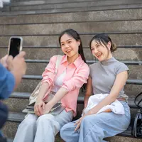 Ilustrasi dua perempuan sedang foto bersama. (cr: BongkarnGraphic/Depositphotos)