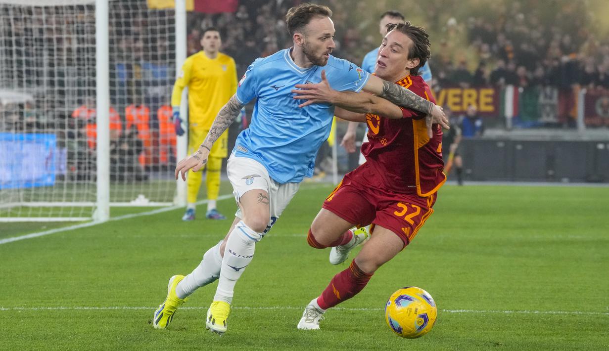 Gelandang AS Roma Edoardo Bove berebut bola dengan gelandang Lazio Manuel Lazzari pada laga perempat final Coppa Italia 2023/2024 di Stadio Olimpico, Kamis (11/1/2024) dini hari WIB. (AP Photo/Gregorio Borgia)