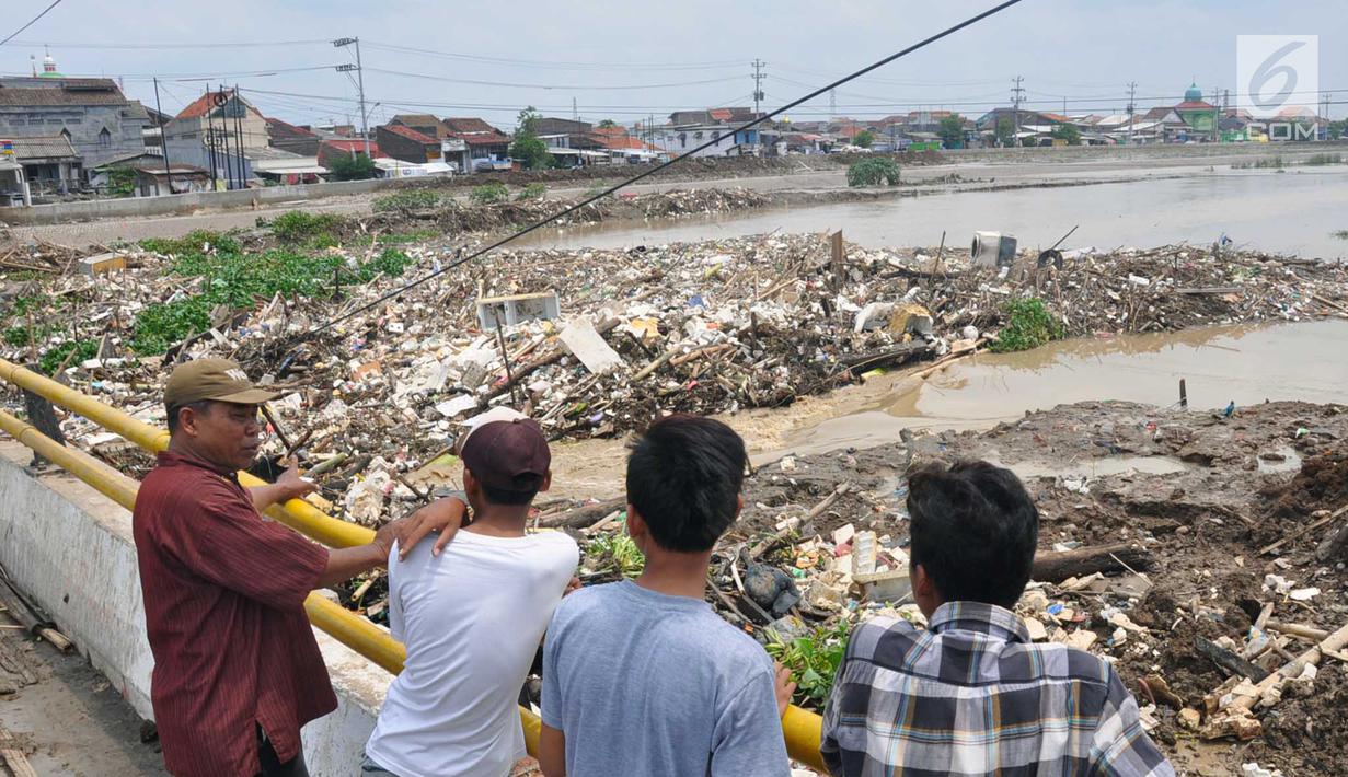 Warga melihat  Tanggul Sungai Banjir Kanal Timur yang jebol, Semarang, Jawa Tengah jebol , Sabtu (8/12). Tanggul yang jebol membuat air sungai mengalir deras ke perumahan warga di kawasan Sawah Besar, Semarang. (Liputan6.com/Gholib)