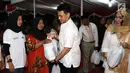 Ketua AMPG DKI Rob Clinton Kardinal memberikan santunan dalam acara buka puasa bersama di Taman pluit, Jakarta Utara, Sabtu (2/5). Buka puasa ini diadakan oleh Angkatan Muda Partai Golkar (AMPG) DKI Jakarta. (Liptan6.com/Angga Yuniar)