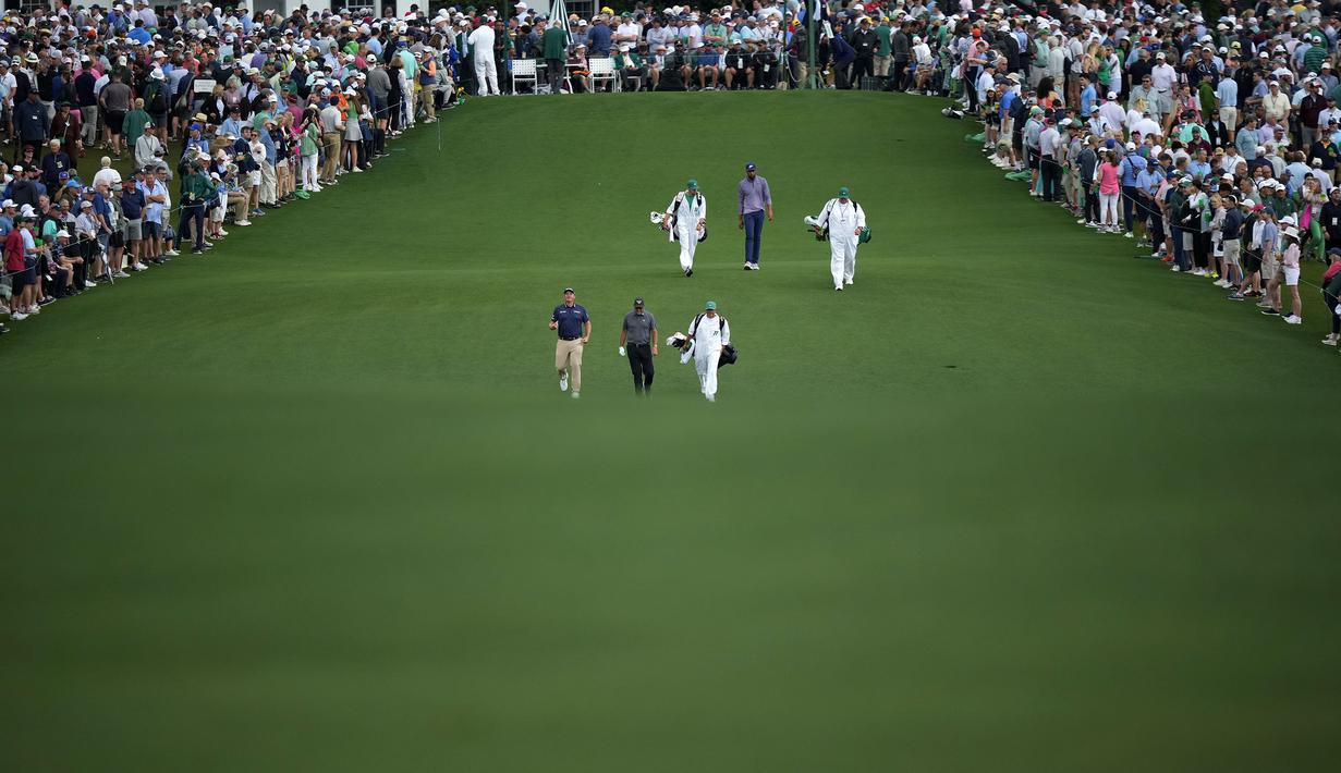 Pegolf Austria, Sepp Straka, Phil Mickelson, dan Tony Finau berjalan menuju ke lubang pertama pada putaran pertama turnamen golf Masters di Augusta National Golf Club, Agusta, Georgia, Kamis (11/04/2024). (AP Photo/Matt Slocum)