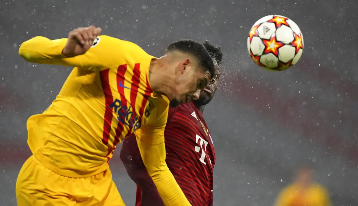 Pemain Barcelona Ronald Araujo (depan) berebut bola dengan pemain Bayern Munchen Alphonso Davies pada pertandingan Grup E Liga Champions di Munich, Jerman, 8 Desember 2021. Bayern Munchen menang 3-0. (AP Photo/Matthias Schrader)
