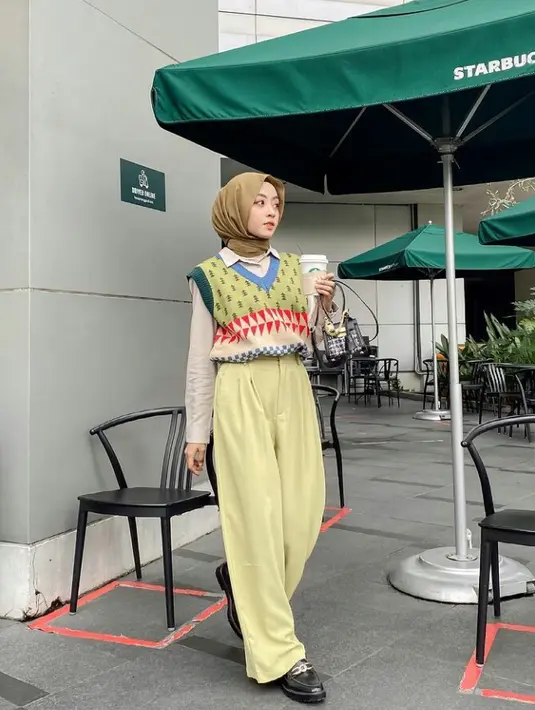 Tampil kece dengan perpaduan vest berpola warna pastel, kemeja putih, hijab pasmina, dan wide leg pants. (Instagram/meiraniap).