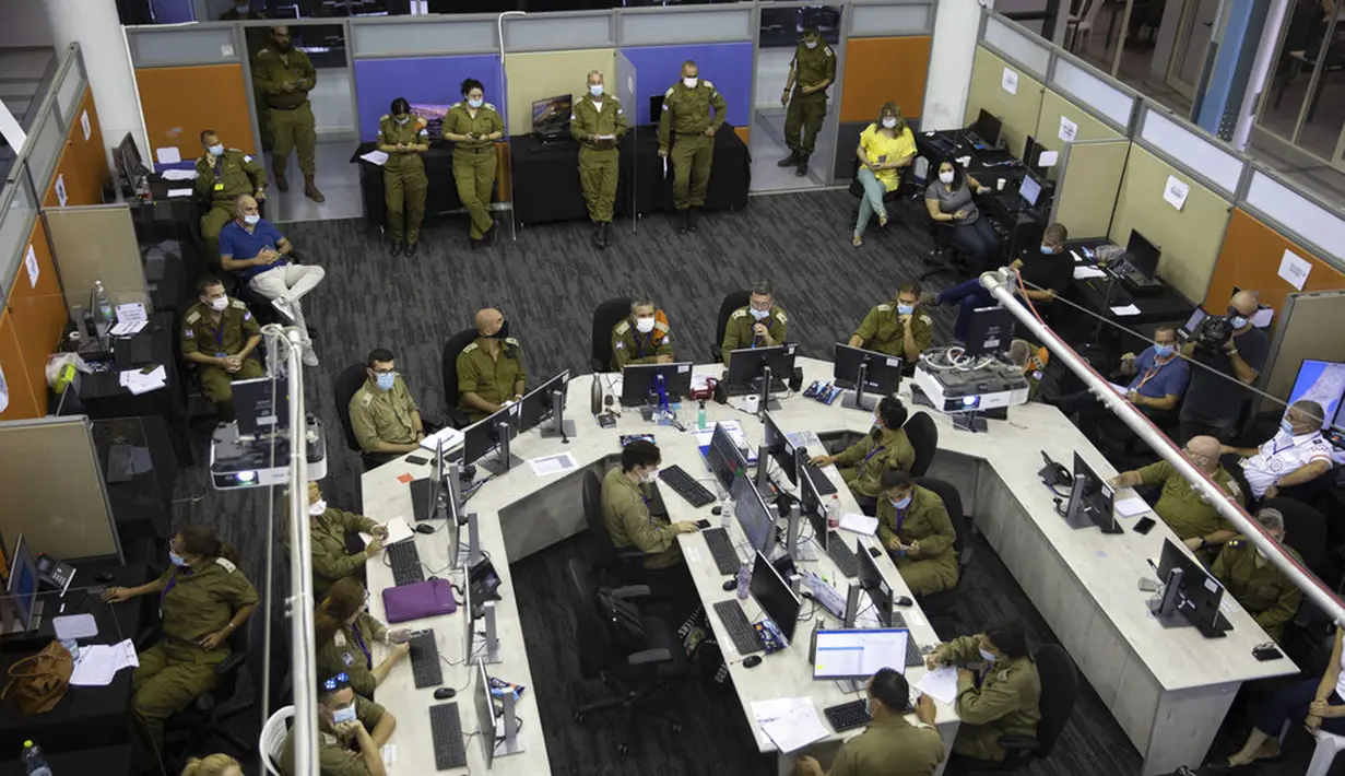 Para tentara bekerja di Ruang Situasi, Markas Home Front Command, Ramle, Israel, 25 Agustus 2020. Militer Israel membentuk satuan tugas baru yang memainkan peran utama dalam melacak kontak dan memutus rantai penularan COVID-19. (AP Photo/Sebastian Scheiner)