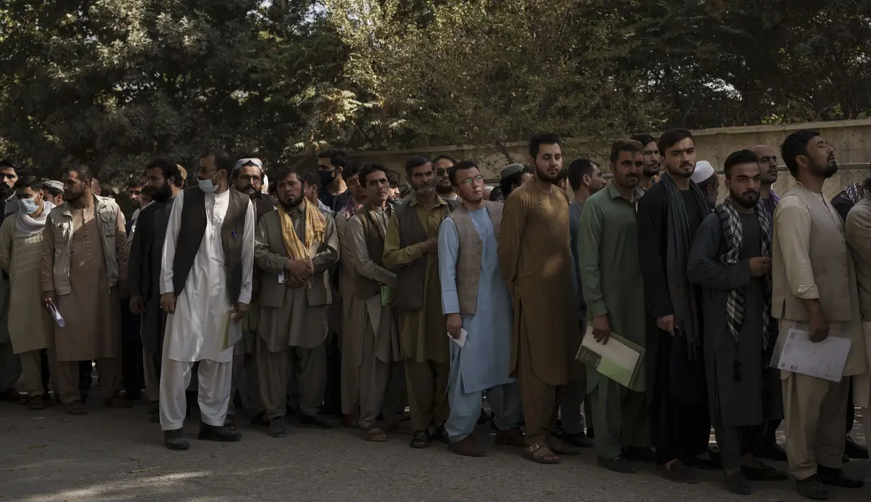Orang-orang berbaris di luar kantor pembuatan paspor pemerintah yang baru-baru ini dibuka kembali di Kabul, Afghanistan, Rabu (6/10/2021). Mereka mengantre setelah Taliban mengumumkan akan mengeluarkan paspor yang disetujui oleh pemerintahan sebelumnya. (AP Photo/Felipe Dana)
