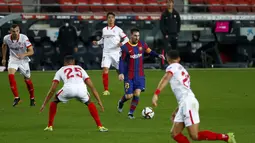 Penyerang Barcelona, Lionel Messi membawa bola saat bertanding melawan Sevilla pada pertandingan leg kedua babak semifinal Copa del Rey di stadion Camp Nou di Barcelona, Spanyol, Kamis (4/3/2021). Barcelona menang agregat 3-2 atas Sevilla. (AP Photo/Joan Monfort)