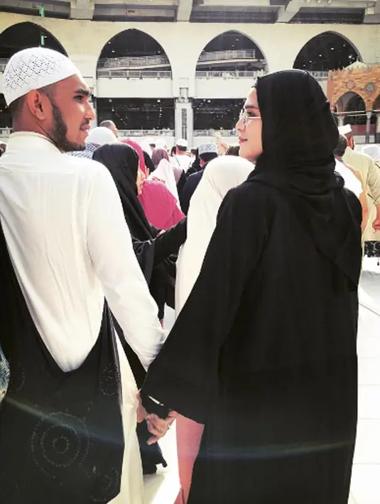Henry Baskoro Hendarso dan Rosmanizar bergandengan tangan saat berada di tanah suci mekah. Keputusan Pria yang akrab disapa Enji ini untuk menceraikan Rosmanizar sudah bulat. (Instagram/@rosmanizar_baskoro)