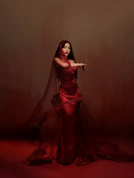 Denada tampil glamor dengan gaun strepless bersiluet mermaid merah menyala rancangan Julia Subekti [@denadaindonesia]