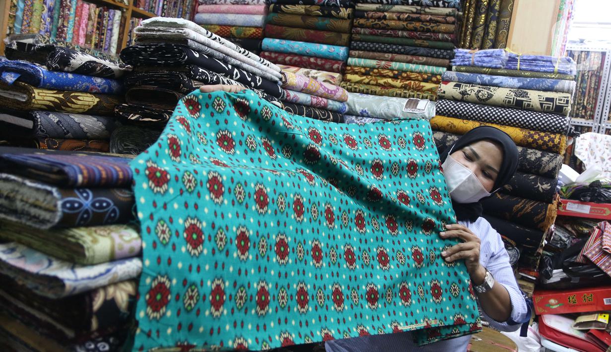 Pekerja menyusun bahan kain di Pasar Tanah Abang, Jakarta, Sabtu (27/11/2021). Utilisasi industri tekstil dan produk tekstil dalam negeri menunjukkan kinerja yang positif menjelang akhir 2021. Utilisasi industri itu berada di posisi 80 - 85 persen pada awal kuartal IV/2021. (Liputan6.com/Angga Yunia