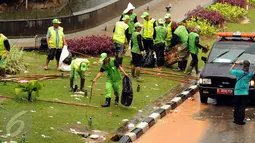 Petugas Pertamanan membersihkan taman di Kawasan Patung Patung Arjuna Wiwaha, Jakarta, Senin (5/1). Ribuan massa buruh ikut dalam perayaan Hari Buruh Internasional 2017. (Liputan6.com/Helmi Fithriansyah)