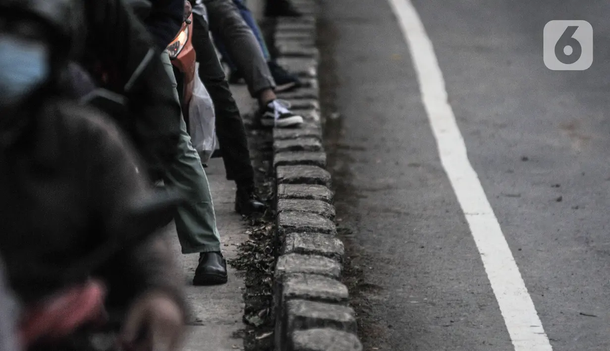 Sejumlah kaki pengendara sepeda motor terlihat saat terjebak kemacetan di Jalan I Gusti Ngurah Rai, Jakarta Timur, Rabu (6/1/2021). Penutupan jalan menyebabkan kemacetan kendaraan saat jam sibuk. (merdeka.com/Iqbal S Nugroho)