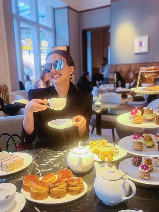 Menikmati afternoon tea di Inggris, Raline Shah menjelma menjadi cewek mamba. Mengenakan blazer hitam, Raline Shah makin kece dengan kacamata hitam. (instagram/ralineshah)