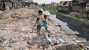 Dua anak bermain di sisa gusuran bangunan di Kali Sekretaris, Kampung Rawa, Jakarta, Selasa (17/11). Warga menyesalkan sikap Gubernur Ahok yang pernah menjanjikan tidak akan ada penggusuran sebelum mendapat kunci rumah susun. (Liputan6.com/Gempur M Surya)