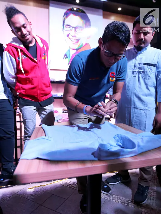 Cawapres nomor urut 02, Sandiaga Uno menandatangani baju pada peluncuran merchandise Thesandiuno, di Jakarta, Senin (04/2). Hasil penjualan merchandise Thesandiuno digunakan untuk mendukung perjuangan Prabowo Sandi. (Liputan6.com/Fery Pradolo)