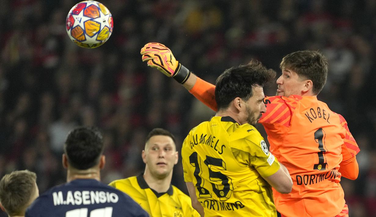Kiper Borussia Dortmund, Gregor Kobel (kanan) berusaha meninju bola untuk mengamankan gawangnya saat menghadapi PSG pada laga leg kedua semifinal Liga Champions 2023/2024 di Parc des Princes Stadium, Paris, Rabu (7/5/2024). (AP Photo/Lewis Joly)