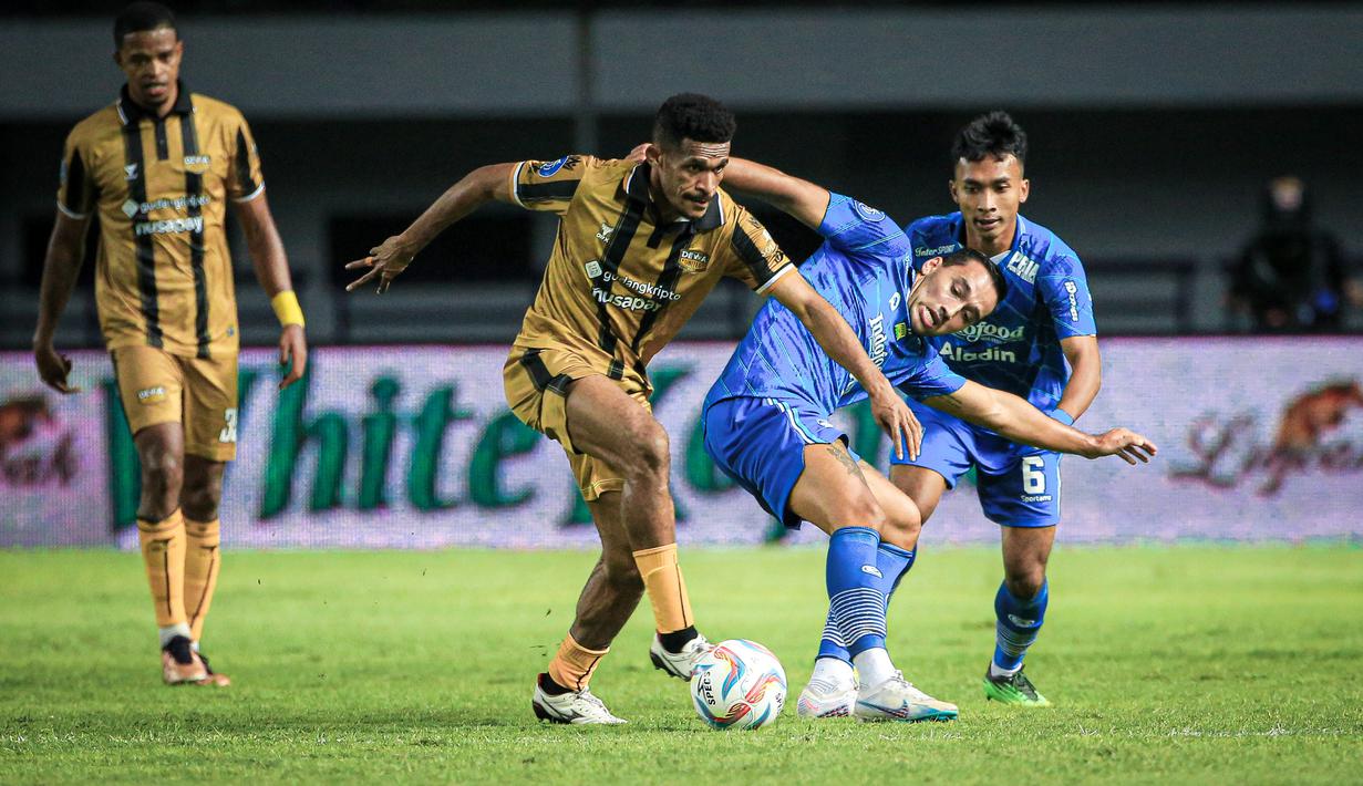 Pemain Persib Bandung, Ezra Walian (kanan), berebut bola dengan pemain Dewa United, Ricky Kambuaya, dalam pertandingan lanjutan pekan ketiga BRI Liga 1 2023/2024 yang berlangsung di Stadion Gelora Bandung Lautan Api, Jawa Barat, Jumat (14/7/2023). (Bola.com/Bagaskara Lazuardi)