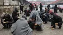 Sejumlah imigran makan makanan yang dibagikan secara gratis di Belgrade, Serbia, Kamis (22/12). (REUTERS / Marko Djurica)