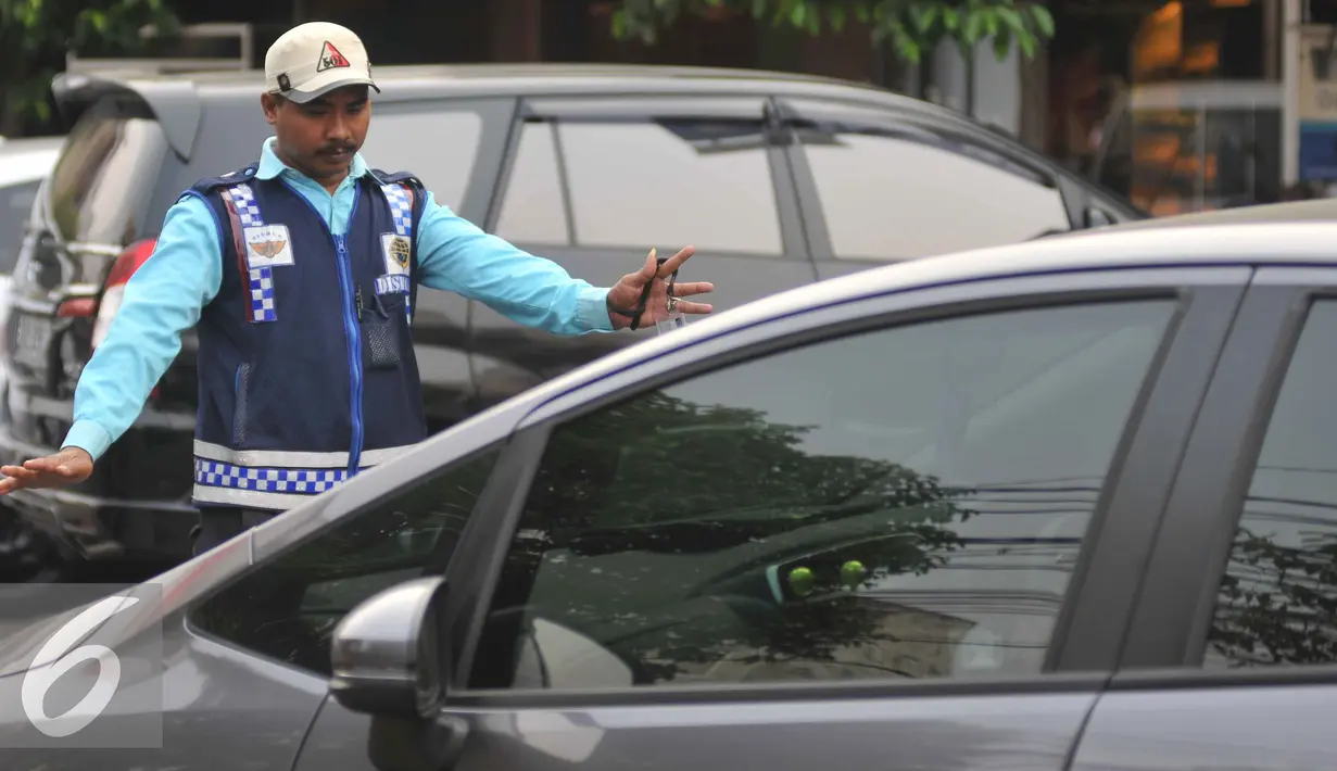 Petugas parkir memakirkan mobil di Jalan Sabang, Jakarta, Senin (21/9/2015). Sesuai janji Unit Pengelola Perparkiran Dishub mereka akan diberi gaji mencapai dua kali upah minimum provinsi (UMP). (Liputan6.com/Gempur M Surya)