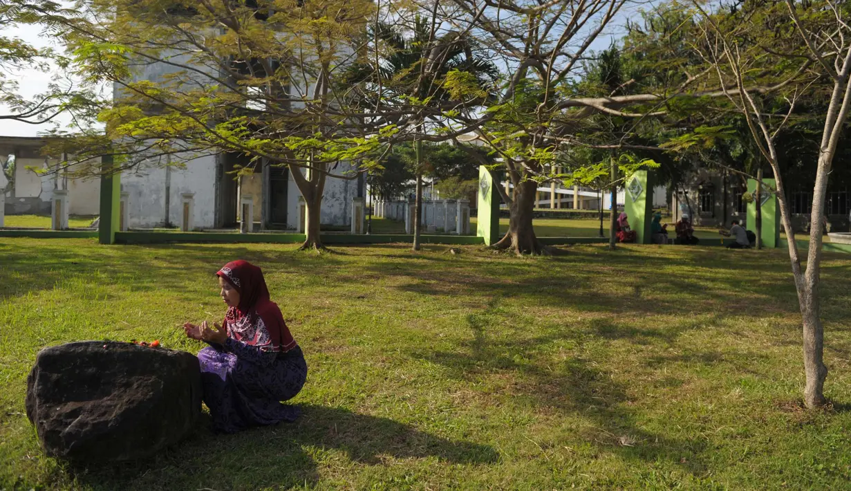 Warga Aceh berdoa di pemakaman massal Ulhee Lheue, Banda Aceh, Sabtu (26/12/2015).  Doa tersebut untuk keluarga mereka yang terkena bencana Tsunami pada 26 Desember 2014. (AFP Photo/ Chaideer Mahyuddin)