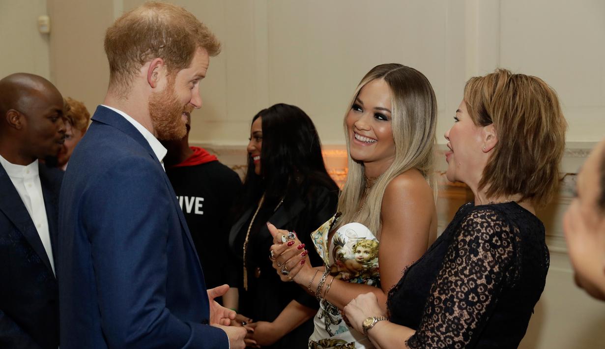 Penyanyi Rita Ora berbincang dengan Pangeran Harry sebelum konser yang diadakan badan amal Sentebale di Hampton Court Palace, London (11/6/2019). Konser ini juga dihadiri aktor David Harewood, James Norton, Tom Hardy dan dan atlet Denis Lewis. (AP Photo/Matt Dunham)