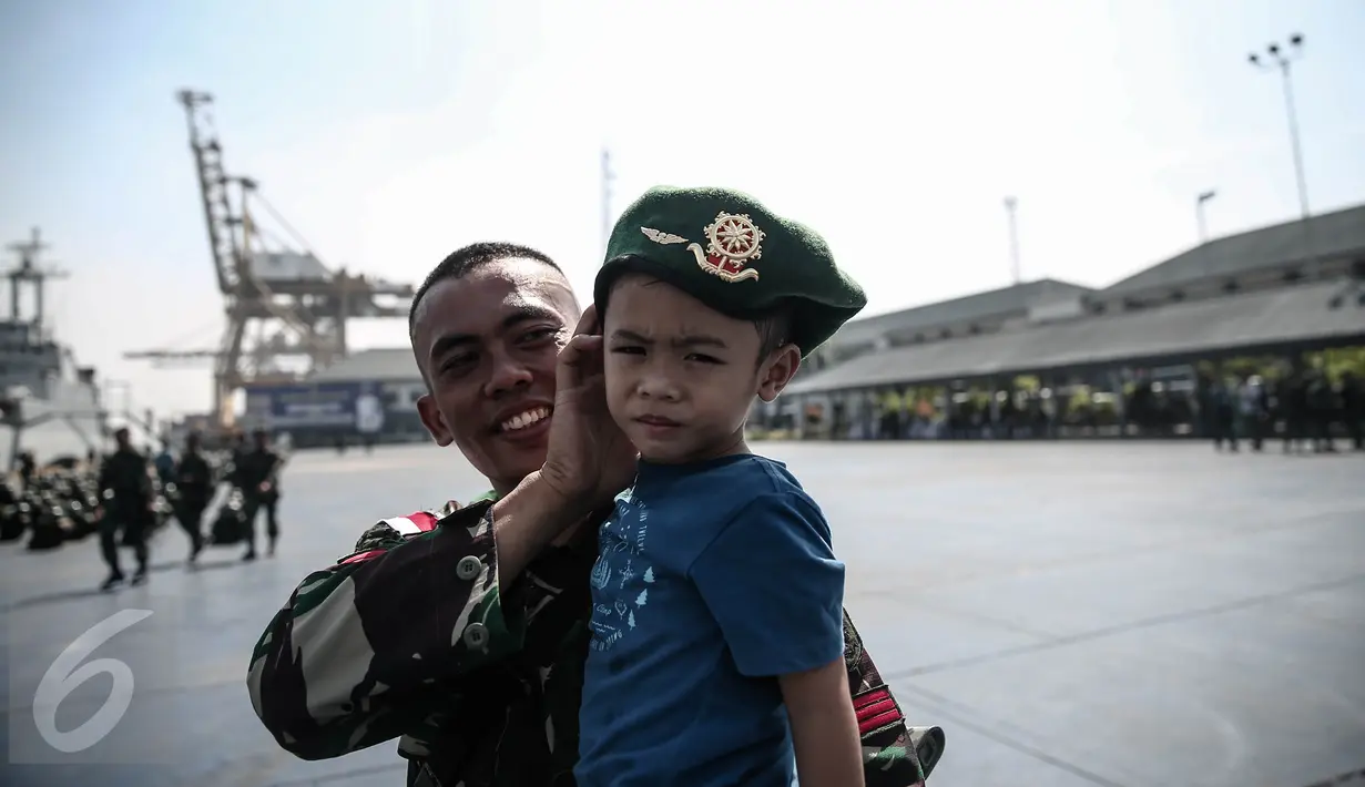 Seorang personel TNI-AD berpose dengan anaknya di Pelabuhan Kolinlamil, Jakarta, Senin (9/5). Sebanyak 450 personel TNI-AD dari Satgas Yonif Para Raider 330 inf 1 Kostrad dilepas untuk misi pengamanan perbatasan RI-PNG. (Liputan6.com/Faizal Fanani)