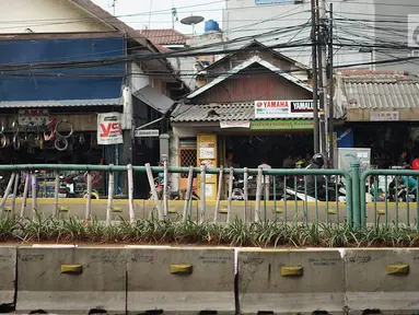 Kondisi pagar pembatas jalur transjakarta yang ditopang bambu di Jalan Otista Raya, Jakarta, Jumat (5/7/2019). Meskipun telah lama rusak, pagar besi berjeruji yang berfungsi sebagai pembatas agar orang tidak menyeberang secara sembarangan itu belum juga diperbaiki. (Liputan6.com/Immanuel Antonius)