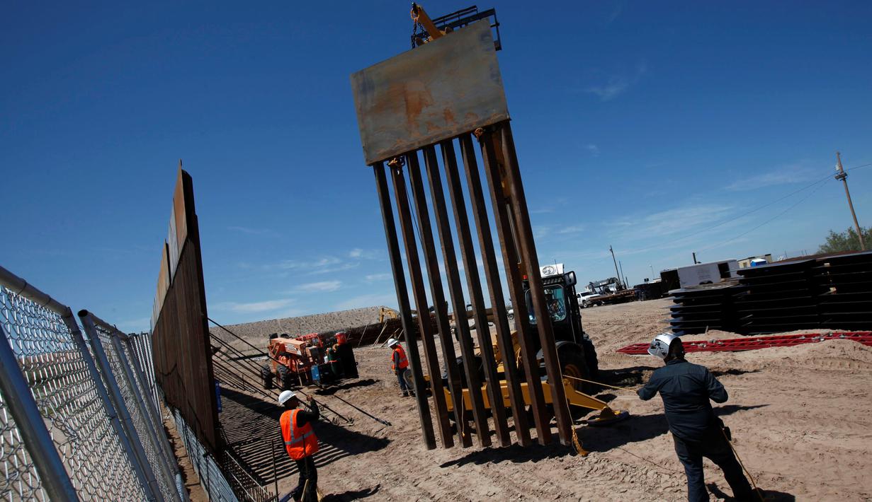 Pekerja memasang pagar pembatas yang merupakan bagian dari dinding perbatasan AS-Meksiko di Sunland Park, AS (09/9). AS dan Mexico dipisahkan oleh sekat teritorial yang menandakan wilayah kedaulatan masing-masing negara. (REUTERS/Jose Luis Gonzalez)
