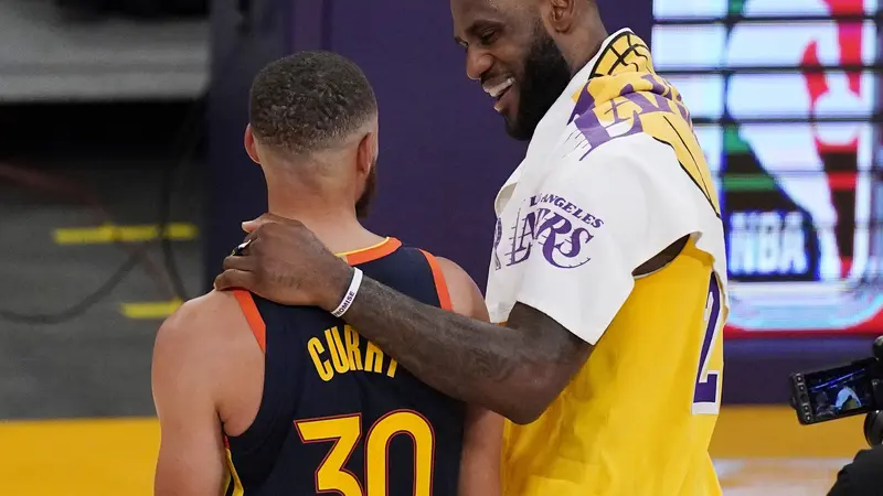 Pebasket Los Angeles Lakers, LeBron James (kanan) merangkul pemain Golden State Warriors, Stephen Curry, setelah berhadapan di play-in-tournament NBA.