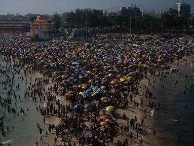 Para penjemur menikmati pantai Macumba, di zona barat Rio de Janeiro, pada 24 September 2023. (Tercio Teixeira/AFP)