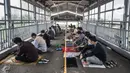 Umat Islam mendengarkan ceramah saat menunaikan salat Jumat di Stasiun Kampung Bandan, Jakarta, Jumat (7/5/2021). Sebagian jemaah menjadikan peron stasiun sebagai tempat salat dan sebagian lain berada di tangga serta jembatan penyeberangan. (merdeka.com/Iqbal S. Nugroho)