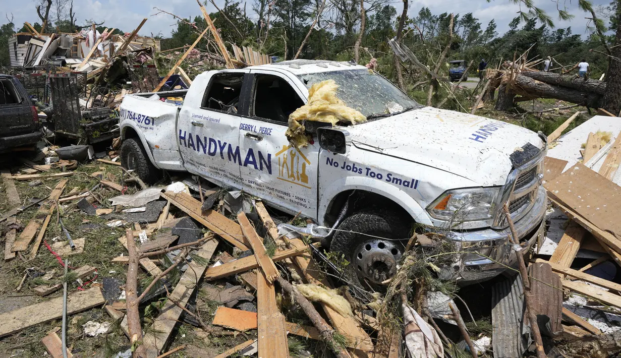 Sebuah kendaraan yang rusak terlihat di tengah puing-puing yang mengotori sebuah rumah setelah tornado melanda Louin, Mississippi, AS, Senin, 19 Juni 2023. (AP Photo/Rogelio V. Solis)