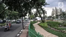 Kendaraan melintas di depan Taman Biotrans, Cempaka Putih, Jakarta, Minggu (19/12/2021). Taman seluas 2.500 meter persegi tersebut diharapkan dapat berfungsi sebagai pengendalian banjir, terbuka hijau serta tempat warga merasakan ruang terbuka yang dekat dengan alam. (merdeka.com/Iqbal S. Nugroho)