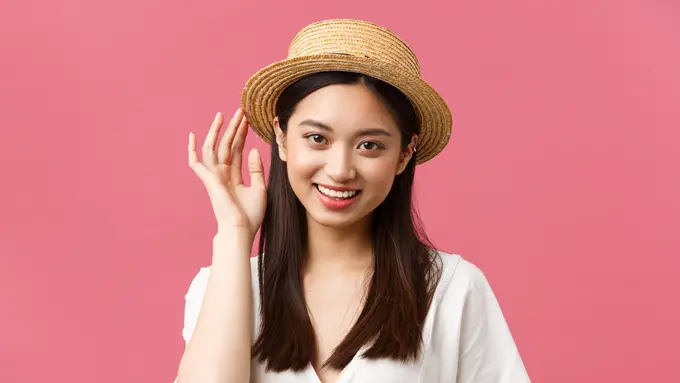 Seorang perempuan menggunakan sebuah topi anyam (Foto Dok: Freepik/benzoix)