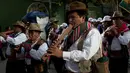 Sejumlah pemain musik pria meniupkan seruling saat prosesi arak-arakan patung dewa Ekeko di La Paz, Bolivia (23/1). Porsesi ini merupakan bagian dari acara pameran miniatur Alasita. (AP Photo / Juan Karita)