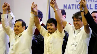 Manny Pacquiao bergandeng tangan bersama senator baru lainnya, Dick Gordon dan Kiko Pangilinan, Filipina, Kamis (19/5). Pacquiao berhasil menduduki 1 dari 12 kursi senator di Majelis Tinggi setelah mendapat 16 juta suara. (REUTERS/Erik De Castro)